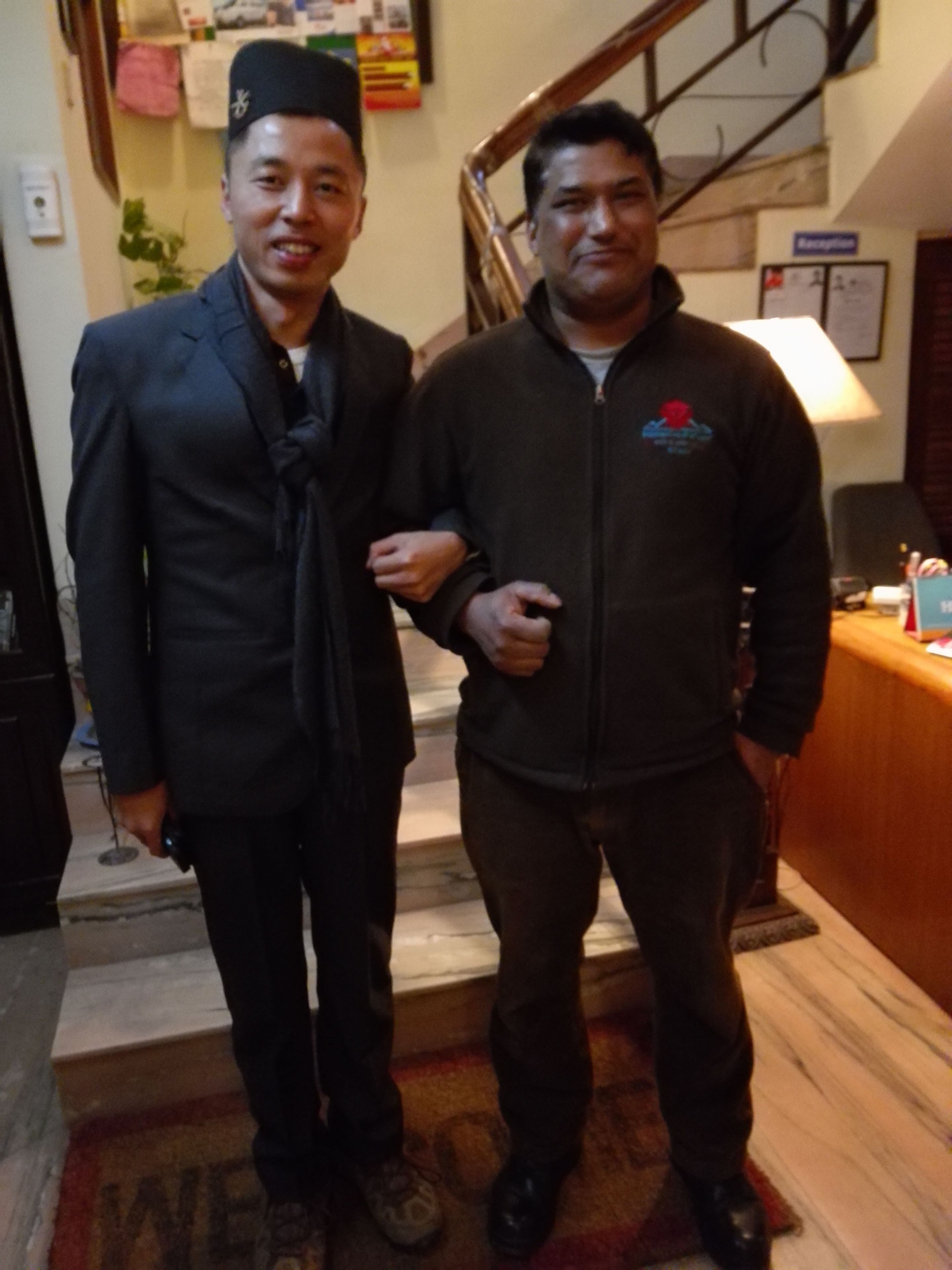 Two men standing on a staircase in a hotel lobby.