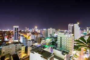 Une vue nocturne d'une ville, avec différents bâtiments, dont un hôtel portant une enseigne sur laquelle on peut lire « Hôtel Van Cleeve ».