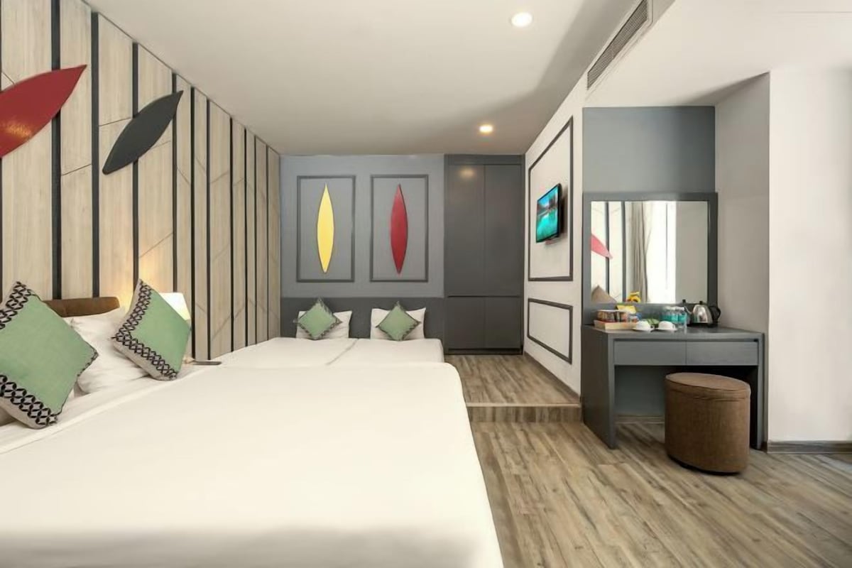 Een moderne slaapkamer met een bed, nachtkastje en bureau met stoel.