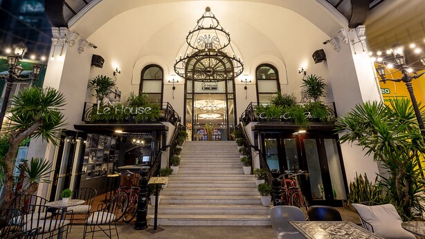 L’entrée du boutique-hôtel LeHouse, avec son grand escalier, son lustre et son espace salon extérieur.