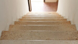 Una escalera con barandilla que lleva a una puerta en la parte superior.