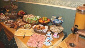 A buffet table with various food items including pastries, fruits, and sandwiches. - Hotel Milano (Trieste)