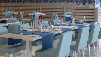 Un restaurante con mesas dispuestas para comer, con manteles y sillas azules a juego.