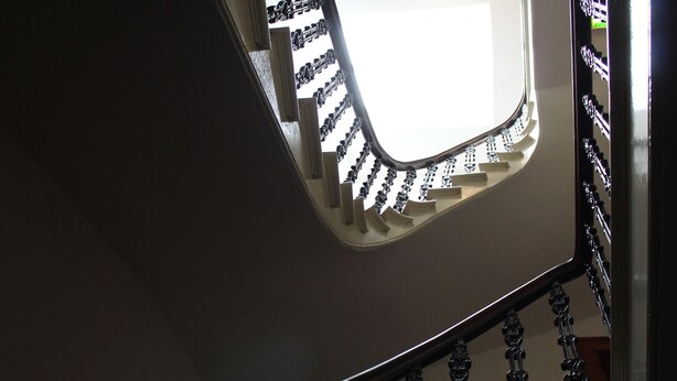 Un escalier en colimaçon doté d’une main courante et de balustres.