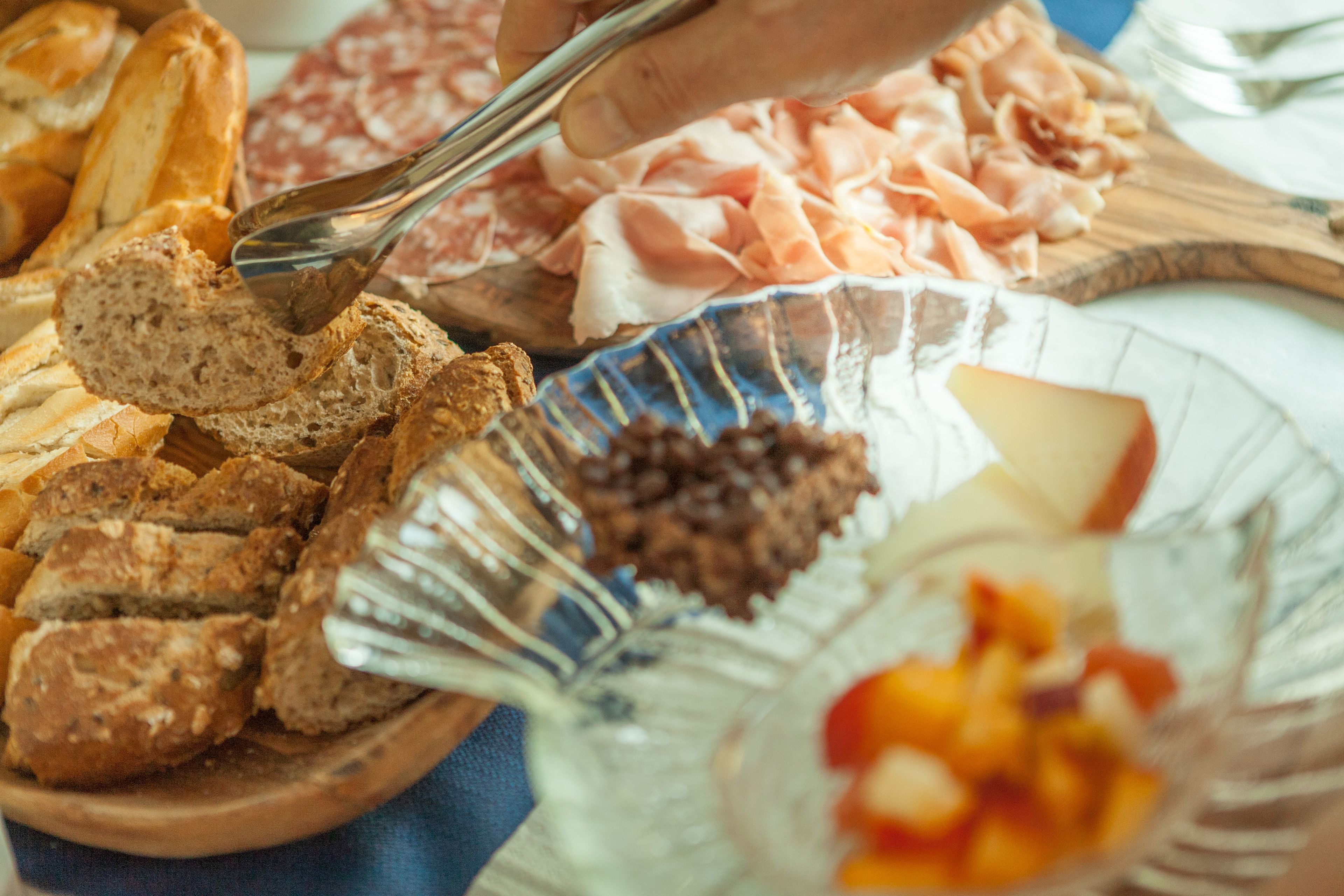 A charcuterie board with various meats, cheeses, and bread.