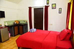 A compact room with a bed, a small kitchenette, and a door. - JES Guest House (Majorda)