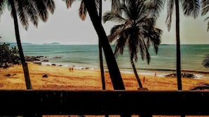 A beach with palm trees and a view of the ocean. - JES Guest House (Majorda)