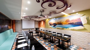 A conference room with a long table, chairs, and a projector screen. - Shi Chi Hotel (Kaohsiung)