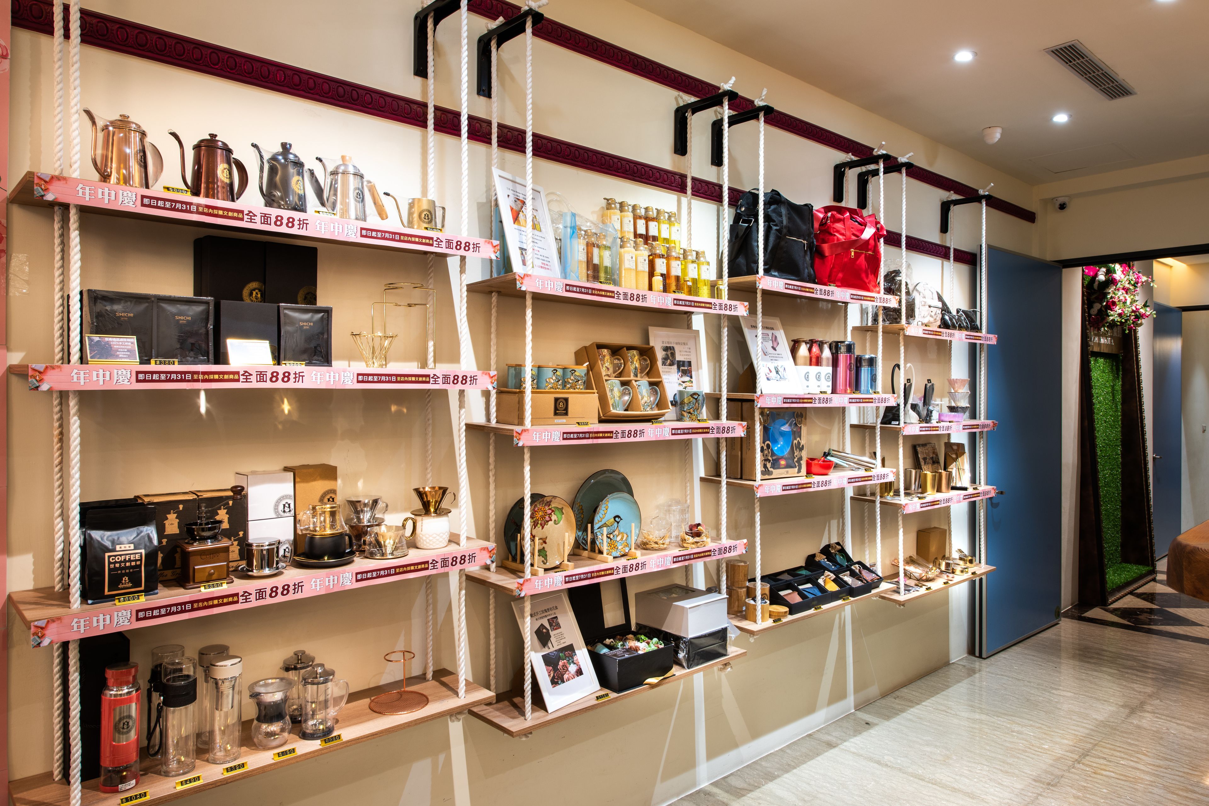 A retail display with shelves stocked with various items, including bags, boxes, and decorative objects.