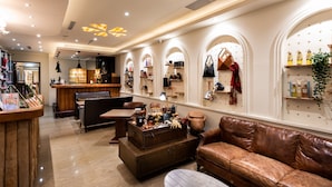 A cozy interior with a bar area, leather seating, and a display of handbags and accessories. - Shi Chi Hotel (Kaohsiung)