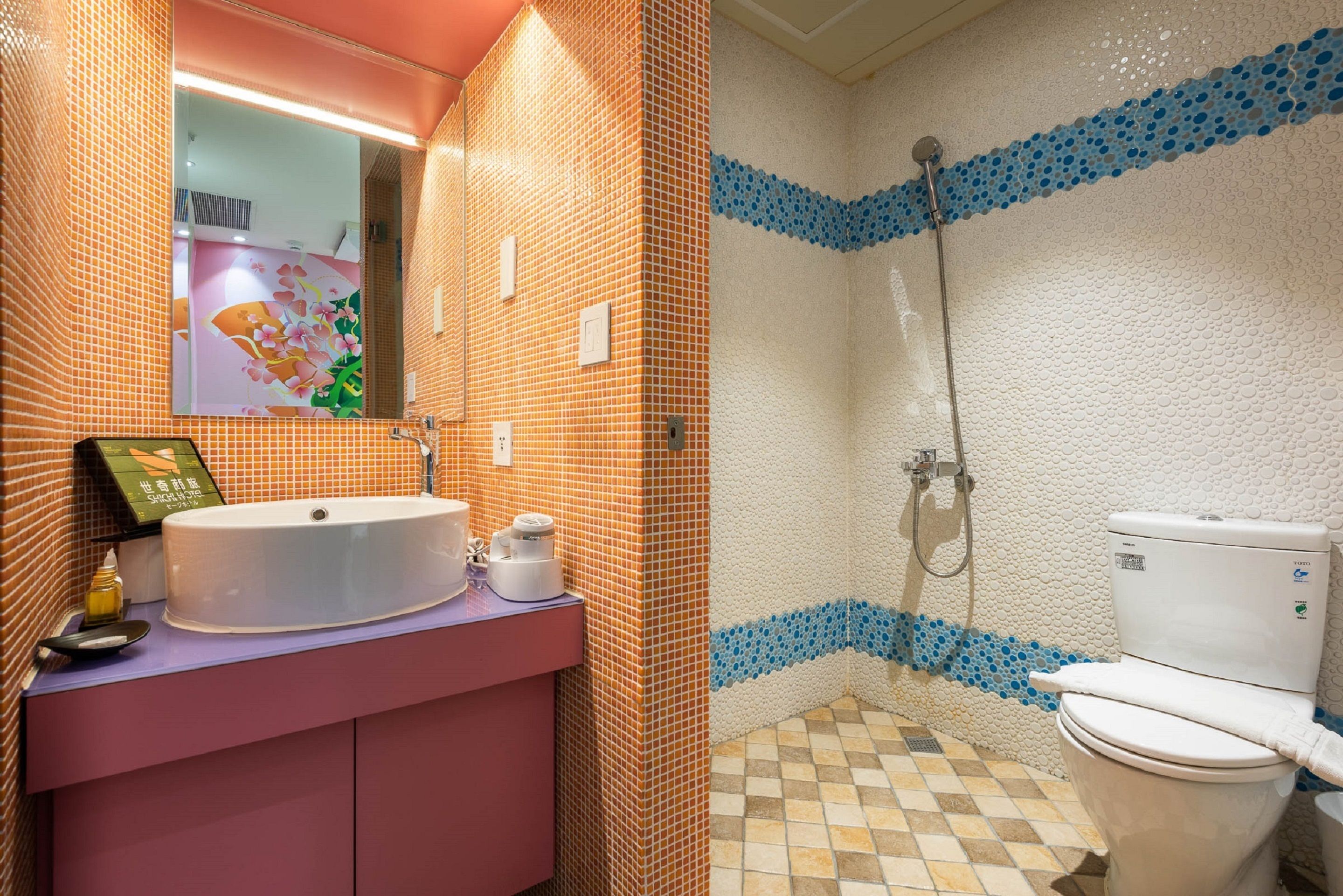 A bathroom with a sink, mirror, and toilet.