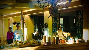 Zona de bar con mostradores de madera, botellas y vasos.