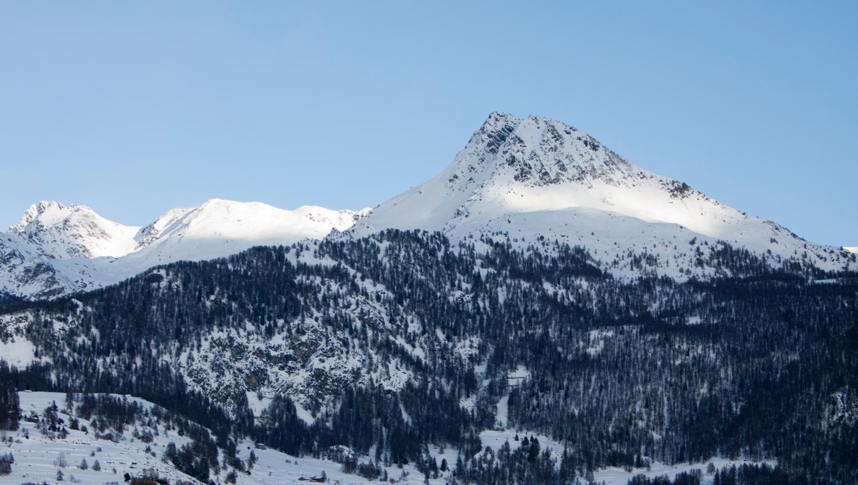 A snow-covered mountain with a clear sky.