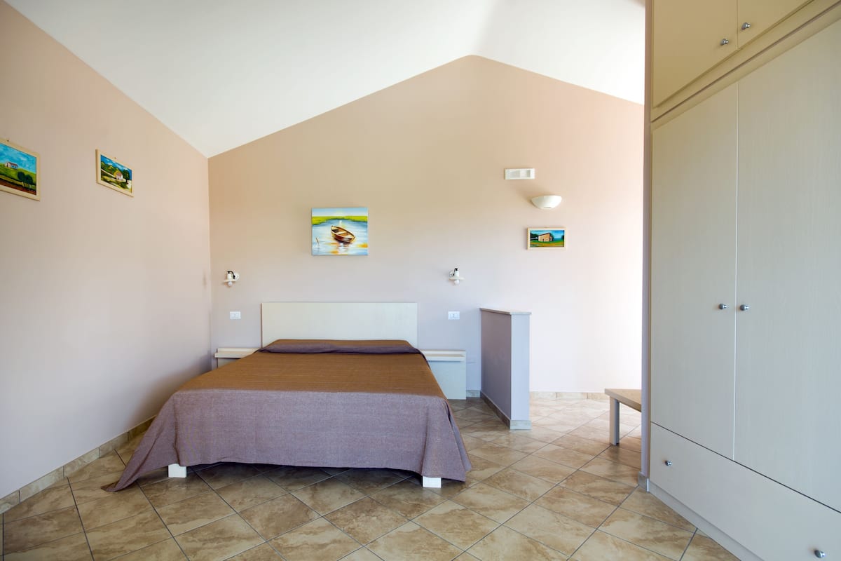 Un dormitorio con cama, escritorio y armario.
