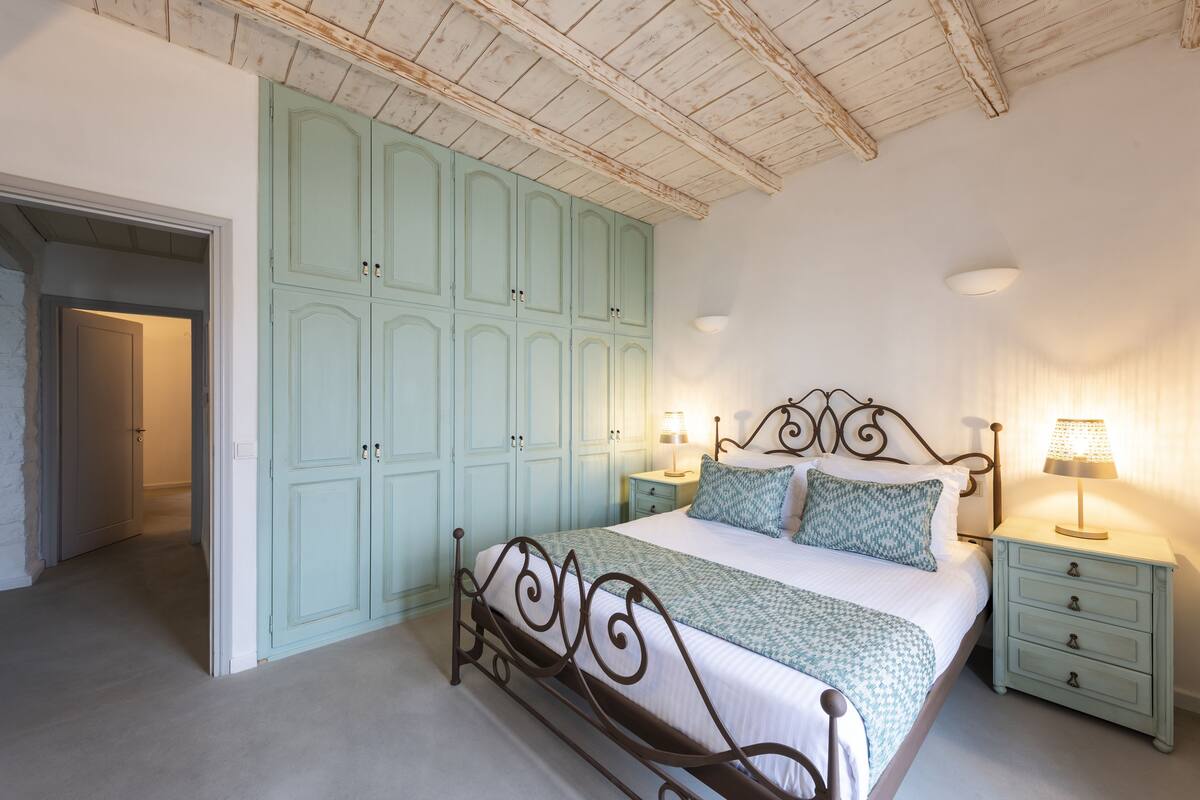 Un dormitorio con cama, mesitas de noche y armario.