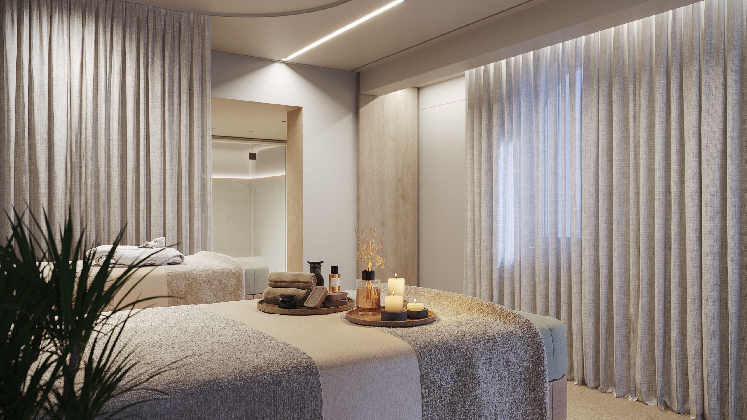 A modern spa room with a large bed, a mirror, and a tray with candles and toiletries.