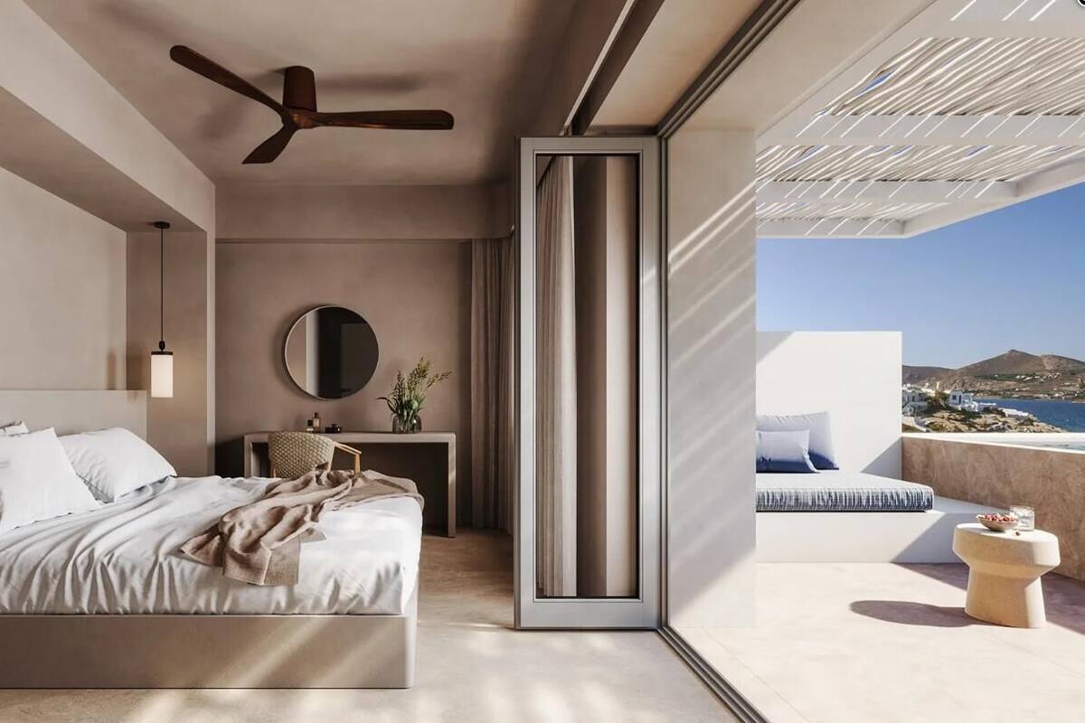 Un dormitorio moderno con cama, mesita de noche y vista al mar.