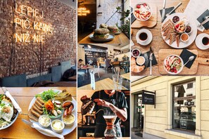 A restaurant interior with brick walls, wooden tables, and a variety of dishes displayed on the tables. - Platinum Aparthotel (Kraków)