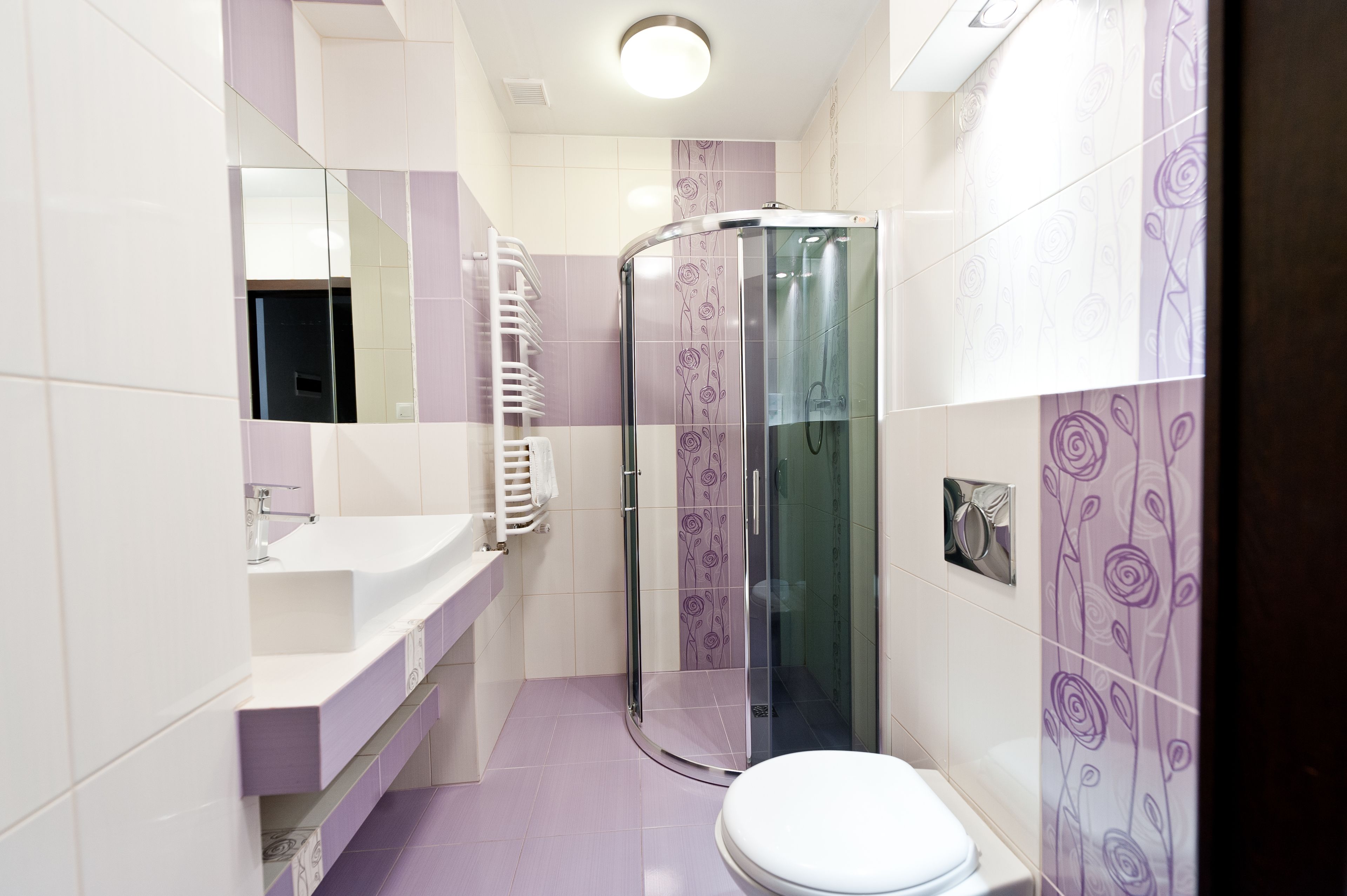 Une salle de bain avec une douche à parois de verre, un lavabo blanc et des toilettes.