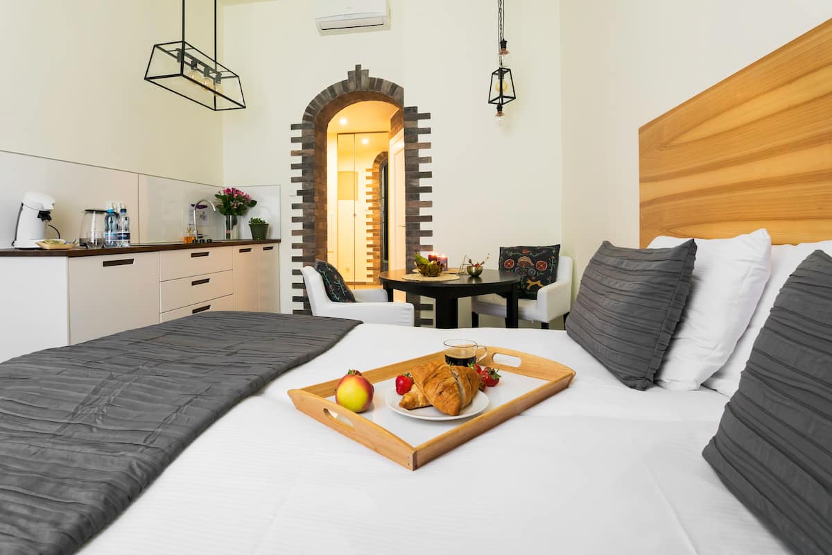 Hotellihuone, jossa on sänky, aamiaistarjoilu ja näkymä ruokasaliin.