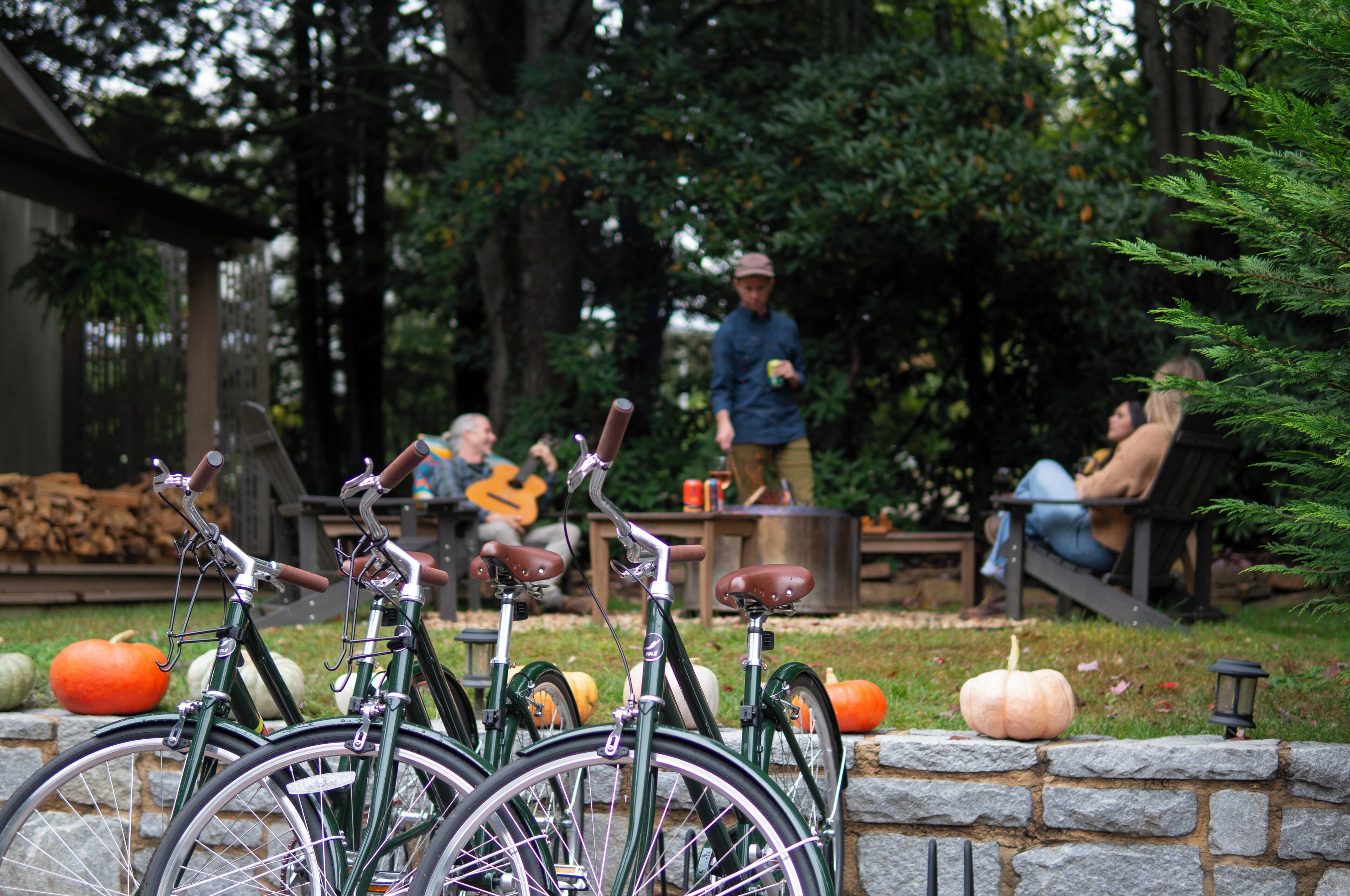 A row of bicycles parked in front of a stone wall.