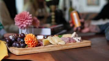 Una tabla de madera con varios quesos, galletas y uvas.