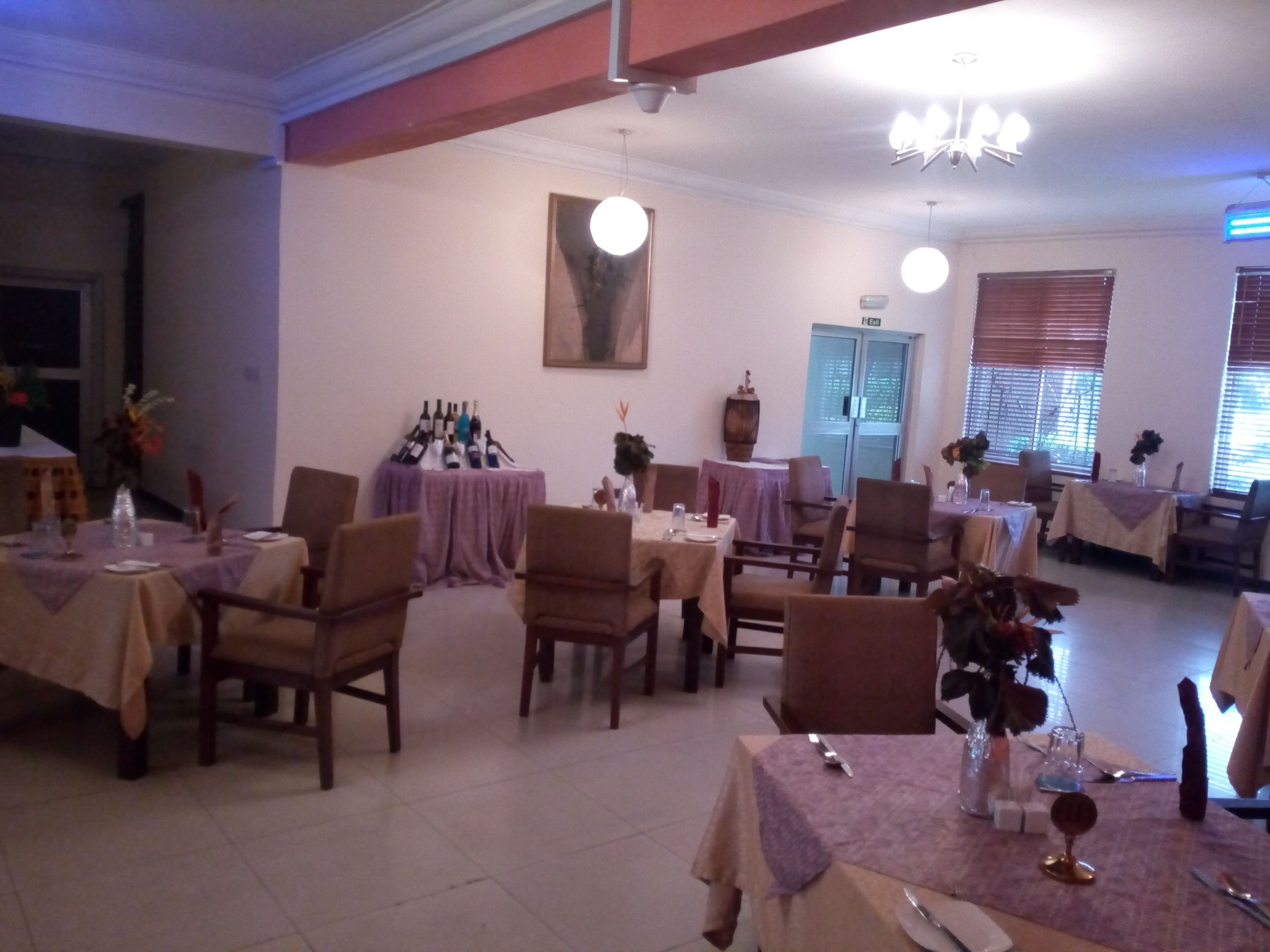 Comedor con varias mesas, sillas y una bodega de vinos.