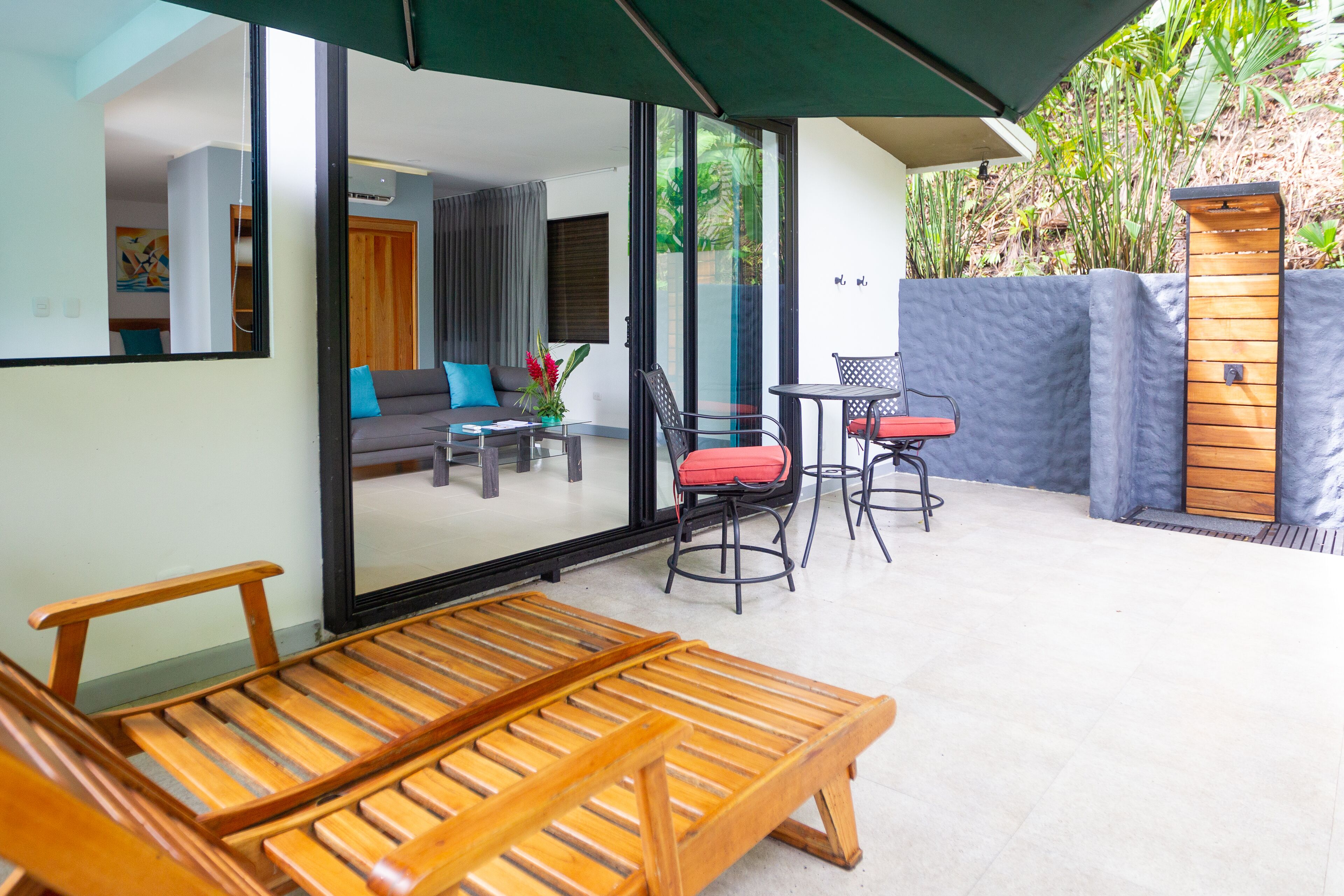 A modern outdoor seating area with a wooden bench, a table, and chairs.