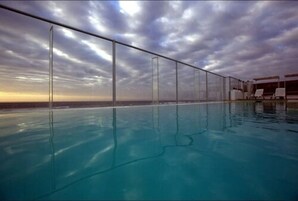 Una piscina al aire libre, tumbonas
