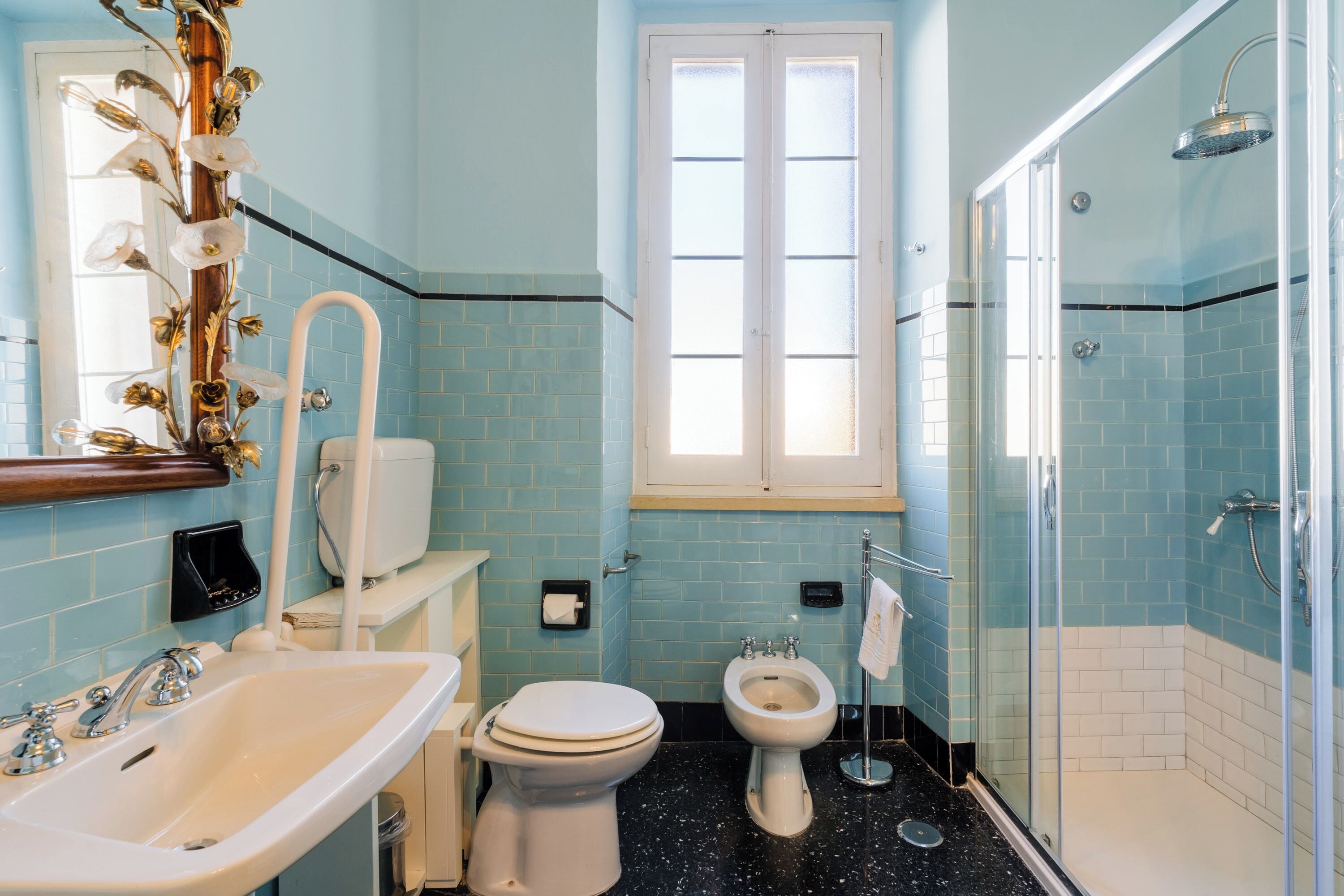 Une salle de bain équipée de toilettes, d’un bidet, d’un lavabo et d’une douche.