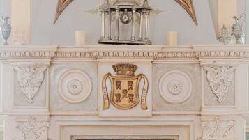 A detailed fireplace with a coat of arms and a clock above it.