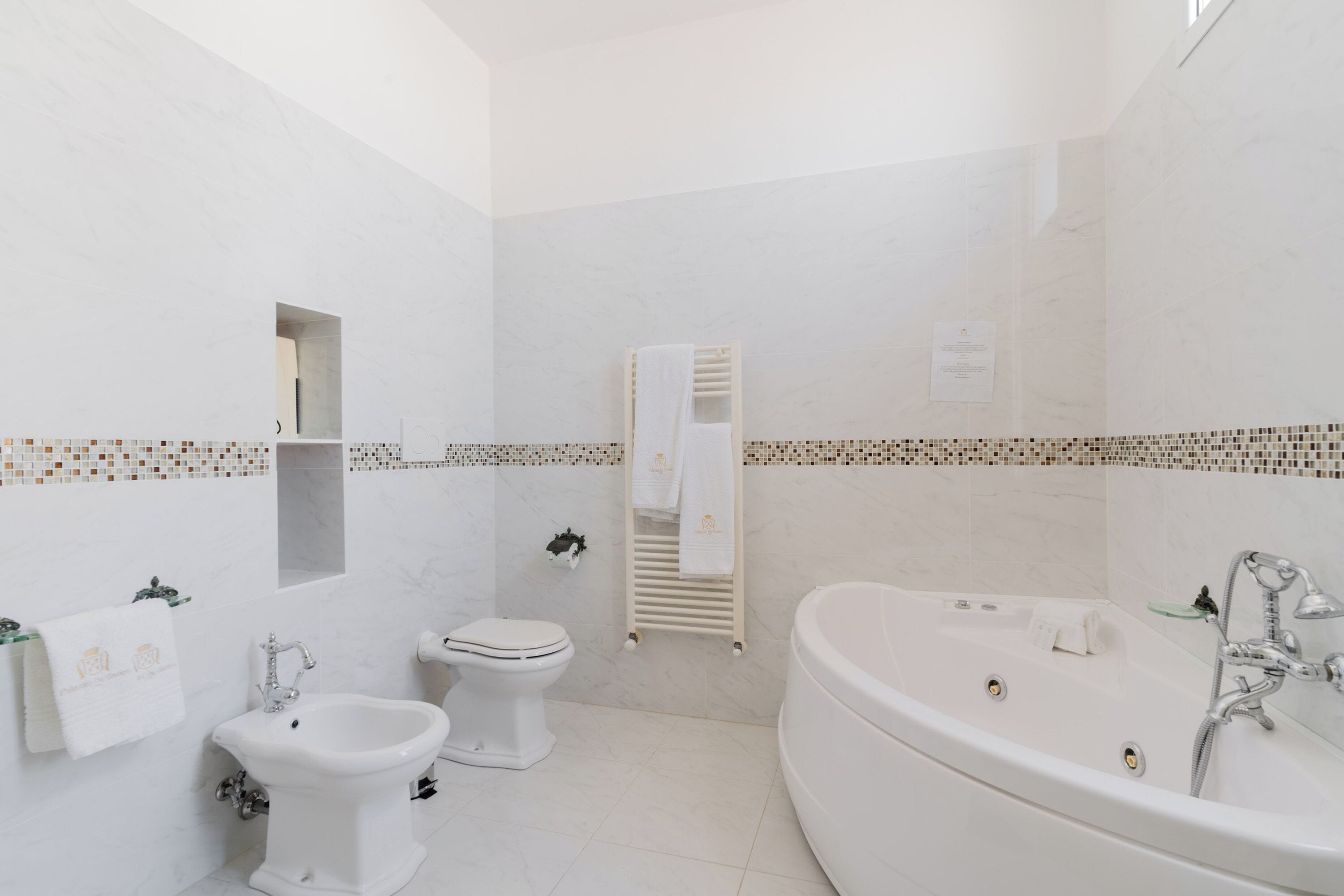 A modern bathroom with a bathtub, a bidet, and a toilet.