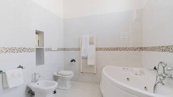 A modern bathroom with a bathtub, a bidet, and a toilet.