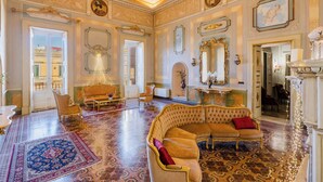 Una sala amplia con decoraciones elaboradas, un sofá grande y una araña.
