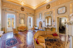Una sala amplia con decoraciones elaboradas, un sofá grande y una araña.