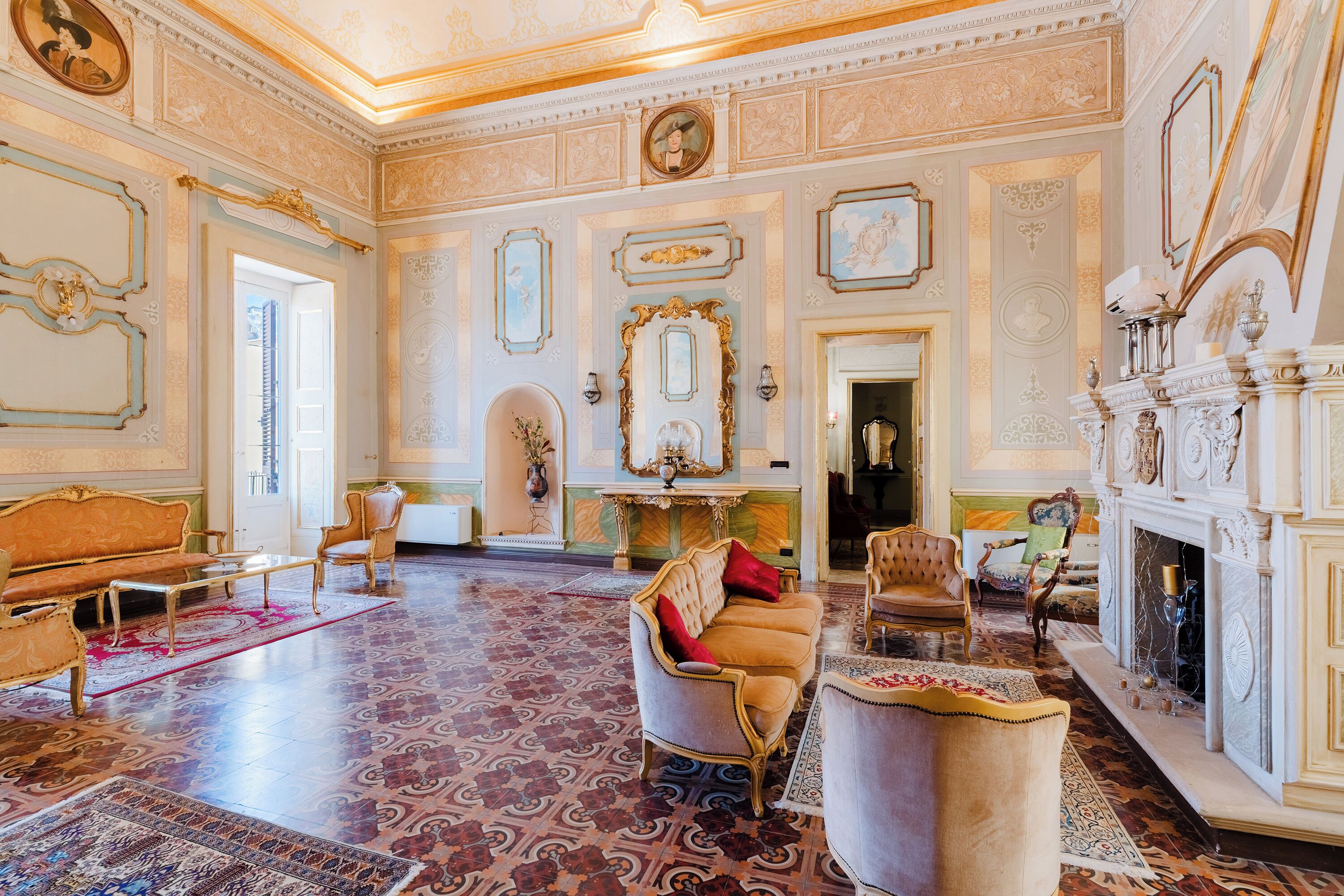 A grand room with ornate decor, a fireplace, and a large mirror.