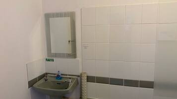 A bathroom with a sink, mirror, and tiled walls.