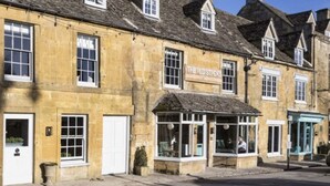 A traditional stone building with a shop on the ground floor. - Old Stocks Inn (Cheltenham)