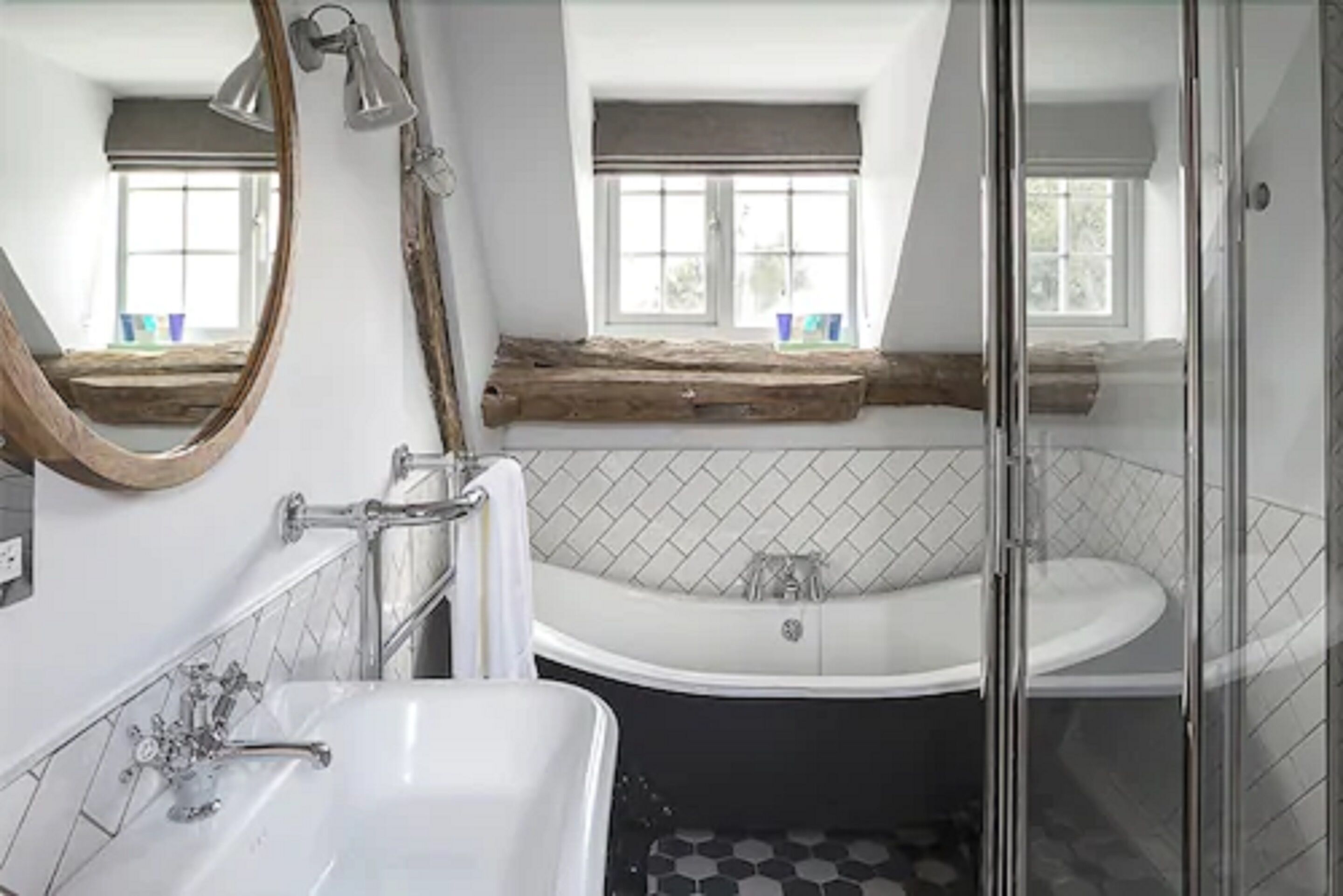 A bathroom with a white sink, a freestanding bathtub, and a glass shower enclosure.