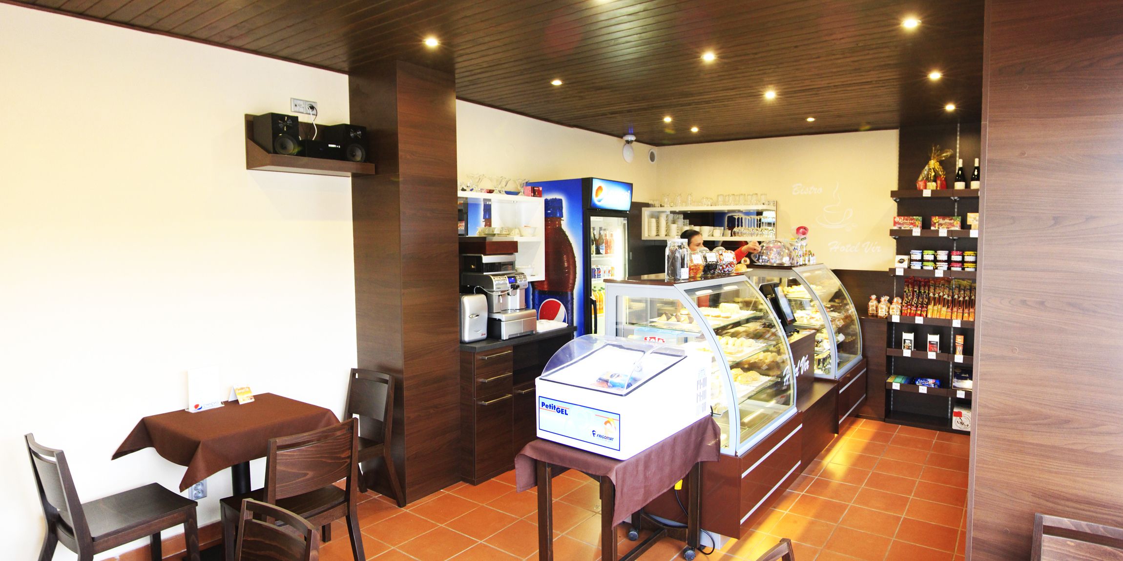 A bakery with a display case, a coffee machine, and a Pepsi refrigerator.