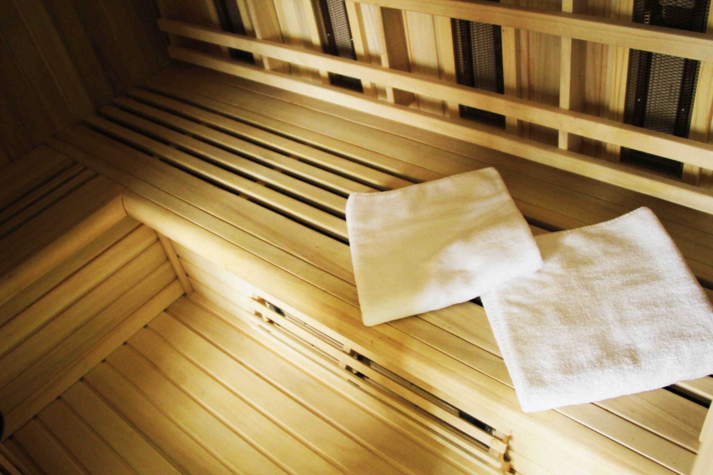 Una sauna con bancos de madera y dos toallas sobre ellos.
