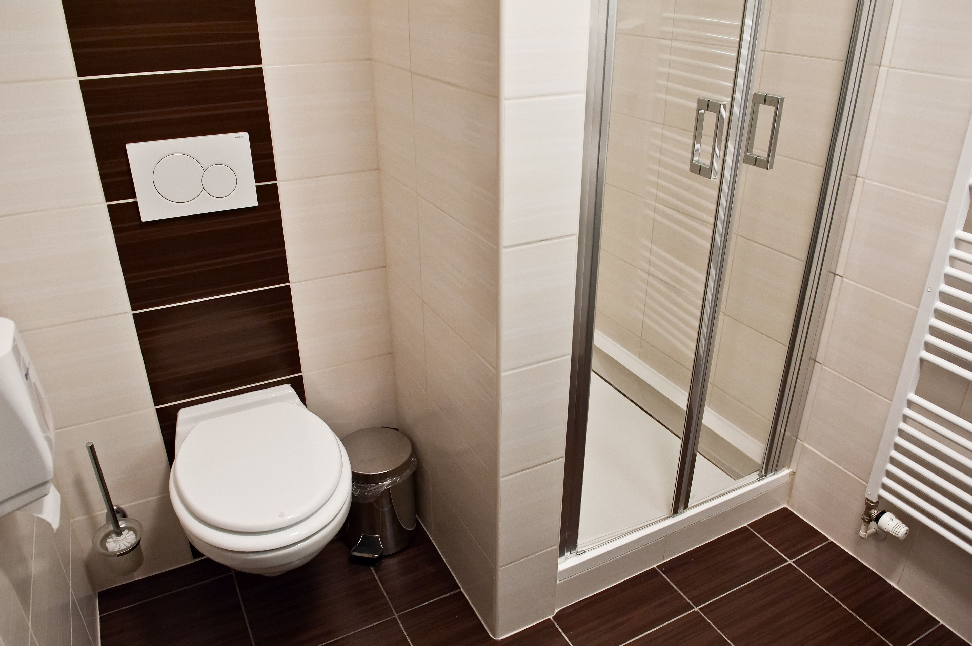 Un baño moderno con inodoro, bidé y ducha con mampara de vidrio.