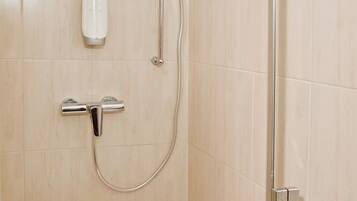 A shower with a handheld showerhead and a wall-mounted faucet.