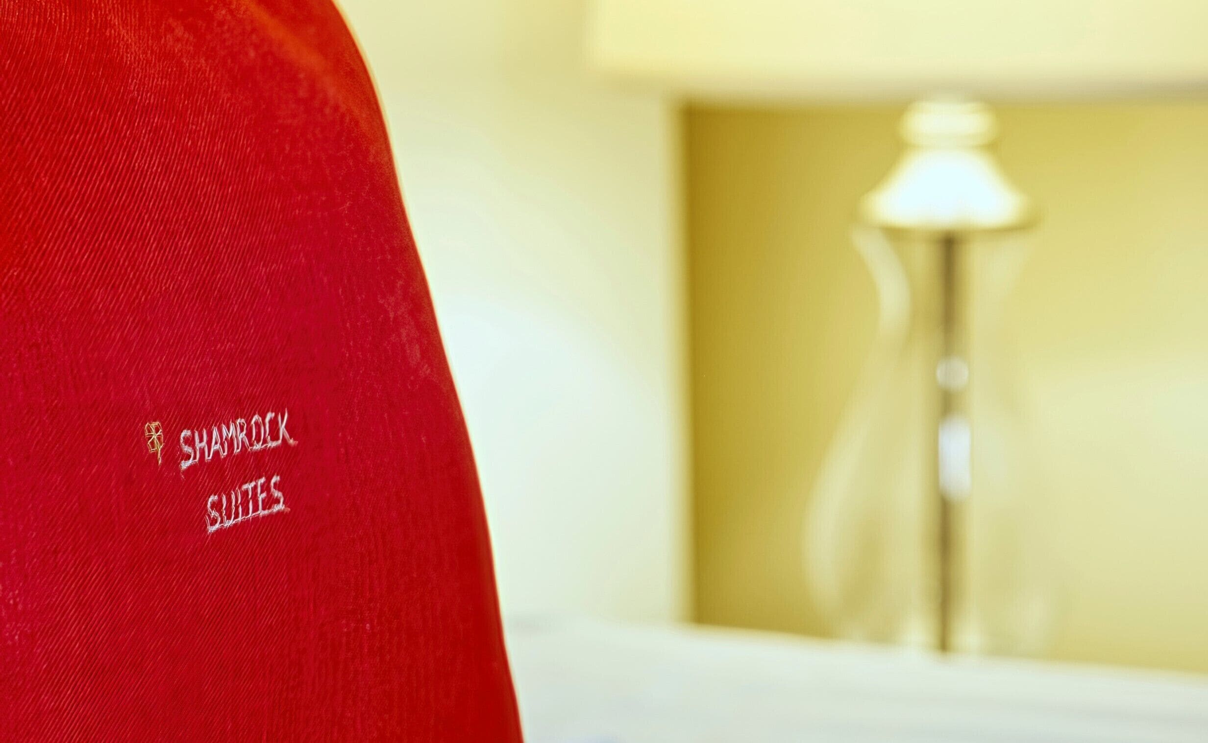 Un vêtement rouge orné d’une inscription brodée : « SHAMROCK GUESTS ».