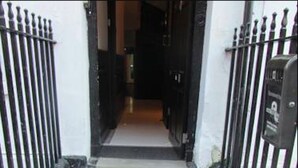 A set of steps leading to a door with a black metal gate. - Goodwood Hotel (London)