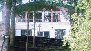 A two-story building with a flat roof, large windows, and a visible chimney.