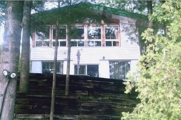 A two-story building with a flat roof, large windows, and a visible chimney.