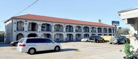 A multi-story motel with a red roof and a sign advertising fast and easy financing.