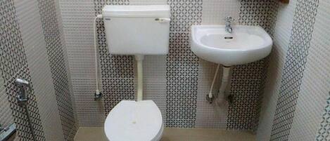 A small bathroom with a toilet, sink, and patterned walls.