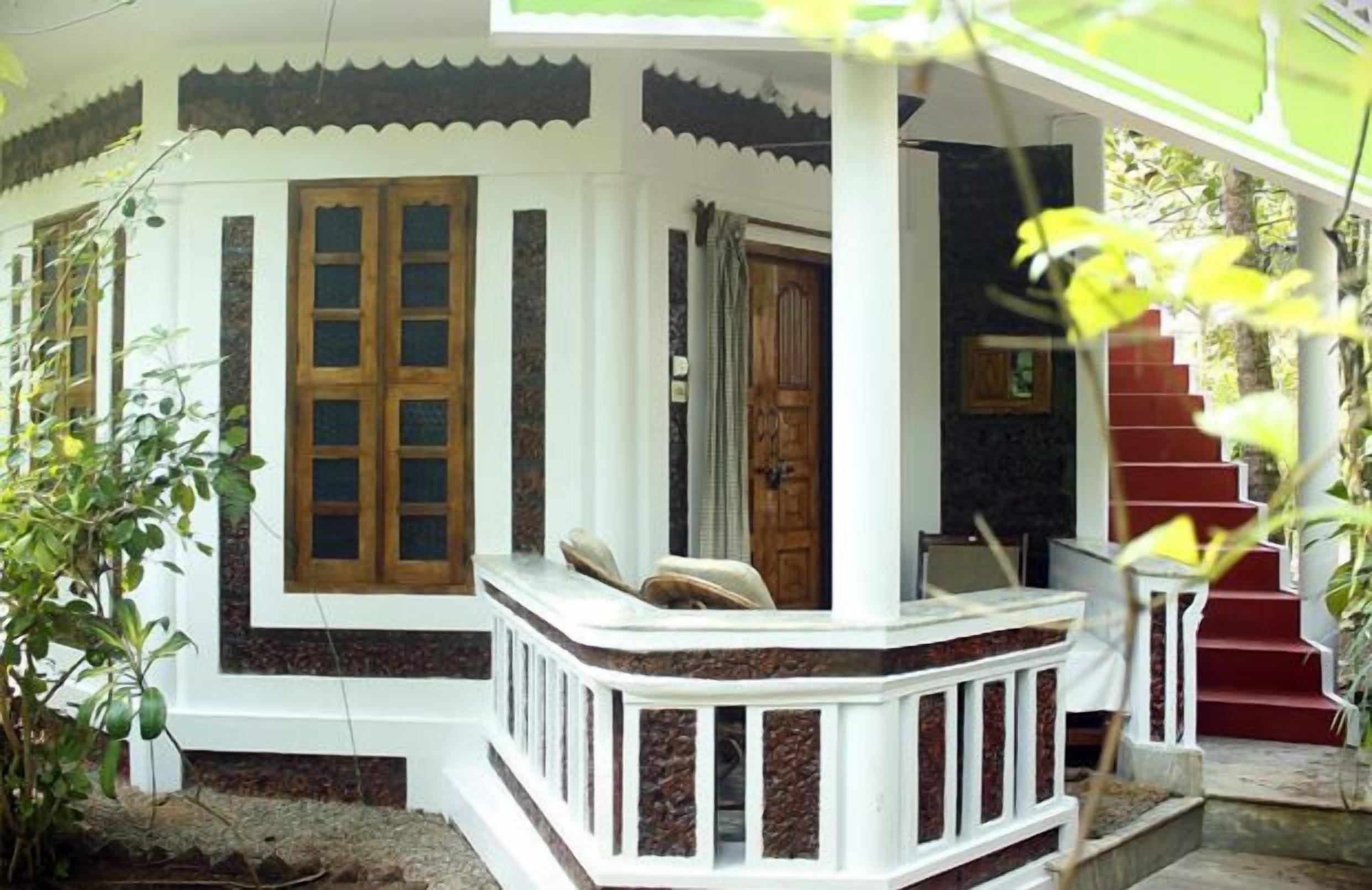 A house with a porch, a wooden door, and a staircase leading to the upper floor.